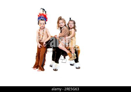 Ein Krieger trägt Gesichtsfarbe und Kriegshaube und führt ein Pony mit zwei Squaws in Hirschhautkleidern und Mokassinen an. Stockfoto