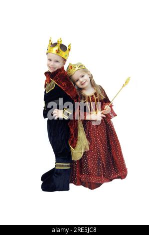 Zwei kleine Kinder ziehen sich in ihren Halloween-Kostümen an. Einer ist als König verkleidet, der andere als Königin. Die Kostüme sind komplett mit Kronen und Skepto Stockfoto