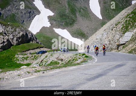 Schmale Gebirgsstraße von Col de Lautaret zum Col du Calibier, Berge und grüne Bergwiesen mit Blick auf Massif des Ecrins, Hautes Alpes, Frankreich Stockfoto