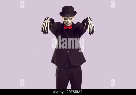 Der Skelettmann im Halloween-Kostüm sieht dich bedrohlich an, während er in Zombie-Pose steht. Stockfoto