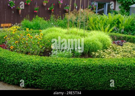 Dekorative Gartenanlage, wunderschöne Gartenelemente im Erholungsbereich im Hof des Hauses Stockfoto