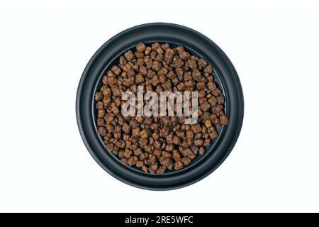Runde Fütterschüssel mit Hund oder Katze Kibble direkt darüber. Isoliert auf weißem Hintergrund. Stockfoto