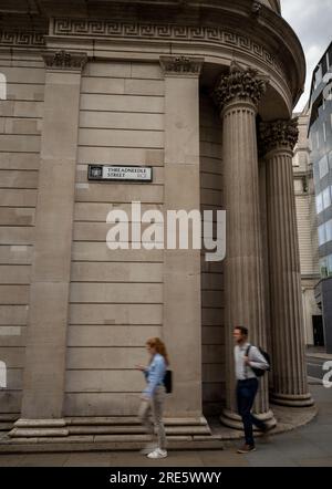 London, Vereinigtes Königreich: Menschen, die an der Bank of England auf der Threadneedle Street in der City of London vorbeigehen. Das Straßenschild ist an der Wand. Stockfoto