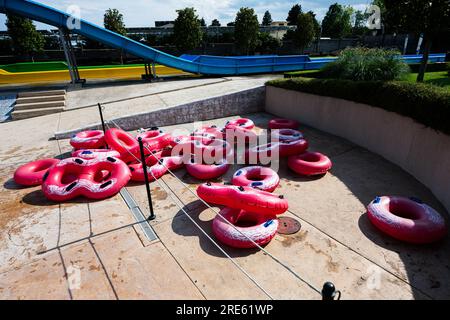 Pinkfarbene aufblasbare Ringe zum Schwimmen in einem Wasserpark an einem sonnigen Tag. Stockfoto