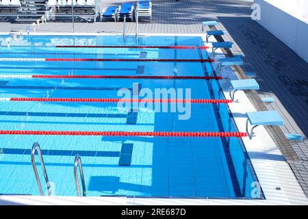 Ein blauer Swimmingpool mit Startplattformen, Markierungen auf den Schwimmwegen, roten schwimmenden Seilbahnen und Startplattformen. Stockfoto