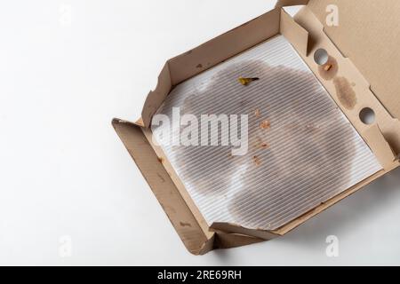 Leere Pizzaschachtel mit Fettflecken auf weiß isoliert. Draufsicht. Stockfoto