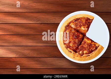 Margherita Pizza auf weißem, rundem Teller auf Holzhintergrund. Auf der Platte fehlt ein Stück. Stockfoto