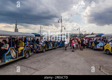 NESEBAR, BULGARIEN - 24. JULI 2019: Touristen, die einen Spielzeugzug in Nesebar, Bulgarien, fahren Stockfoto