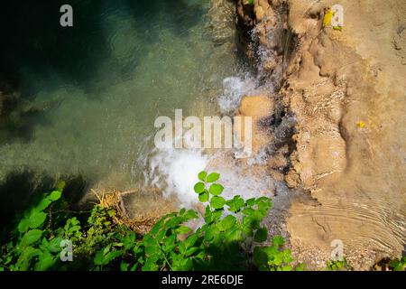 Wagen Sie sich in eine magische Welt der Waldwasserfälle, wo die Kunst der Natur atemberaubende türkisfarbene Seen enthüllt. Tauchen Sie ein in das ruhige B Stockfoto
