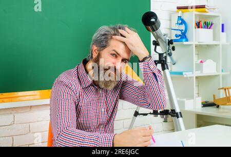 Männlicher Student, der sich auf den Test oder die Prüfung vorbereitet. Zurück in die Schule. September 1. Nachhilfelehrer bereitet Unterricht im Klassenzimmer vor. Lernen. Student sitzt am Schreibtisch Stockfoto