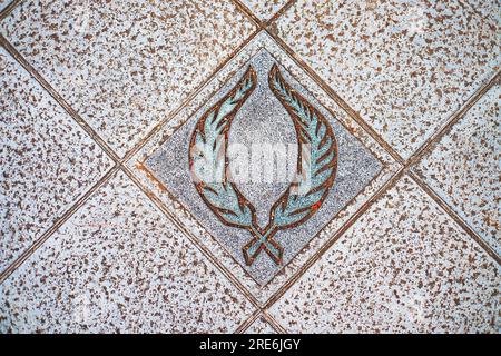 Laurel-Kranz, Symbol für Triumph und Ruhm, ein dekoratives Relief in einem Pflasterstein. Stockfoto