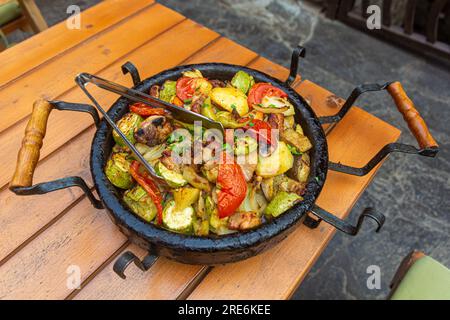 Typisch bulgarisches Essen - Gemüse, das in einem Topf namens sach gebacken wurde Stockfoto