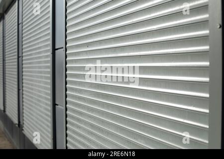 Jalousien am Fenster. Plastikläden. Gerippte Oberfläche. Fenster geschlossen. Stockfoto