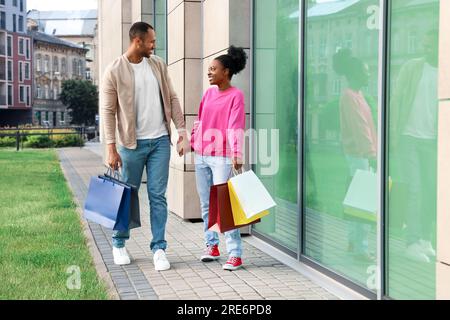 Familieneinkäufe. Glückliches Paar mit bunten Taschen in der Nähe des Einkaufszentrums im Freien Stockfoto