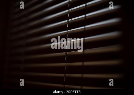 Jalousien im dunklen Raum. Geschlossenes Fenster. Geschlossene Jalousien. Licht durch Hindernis. Stockfoto