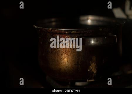Ein alter Topf am Morgen in der Küche. Rostige Pfanne. Küchendetails. Plaque auf Stahl. Stockfoto