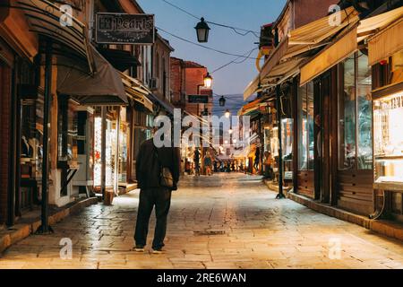 Ein Mann spaziert nachts auf der Salih Asim Straße im Alten Basar von Skopje, Nordmazedonien Stockfoto