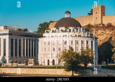 Das runde Verwaltungsgebäude des Department of Water and Sewer in Skopje, Nordmazedonien. Die Grünkohl-Festung ist dahinter zu sehen Stockfoto