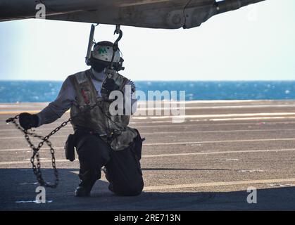 INDISCHER OZEAN (24. Juli 2023) Aviation Structural Mechanic (Safety Equipment) 3. Klasse Ryan Christopher Deiz, aus Stockton, Kalifornien, Ketten an F/A-18E Super Hornet, angeschlossen an das Dambusters of Strike Fighter Squadron (VFA) 195, an das Flugdeck der USA Der einzige Flugzeugträger der Navy, USS Ronald Reagan (CVN 76), während des Flugbetriebs zur Unterstützung von Talisman Sabre 23 im Indischen Ozean, am 24. Juli 2023. Ronald Reagan, das Flaggschiff der Carrier Strike Group 5, stellt eine kampfbereite Truppe bereit, die die Vereinigten Staaten schützt und verteidigt und Bündnisse und Partnerschaften unterstützt Stockfoto