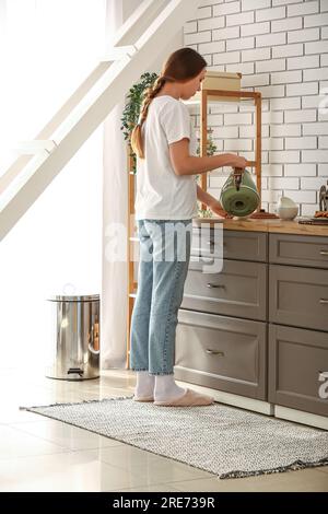 Frau stehend auf Teppich in der Küche Stockfoto