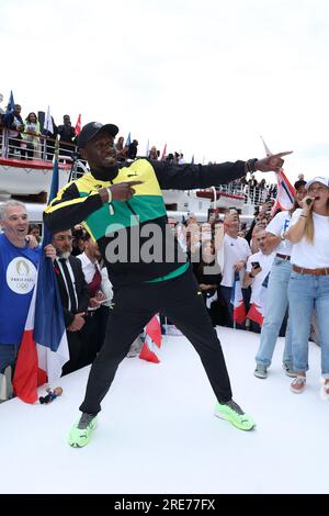 Usain Bolt posiert am 25. Juli 2023 mit der Paralympischen und Olympischen Fackel 2024 in der Nähe des Eiffelturms am Ufer von Paris, Frankreich, während einer Reise auf der seine mit französischen Sportlern, um die offizielle Fackel für 2024 zu präsentieren.Foto von Jerome Domine/ABACAPRESS.COM Kredit: Abaca Press/Alamy Live News Stockfoto