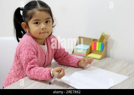 2-jähriges lateinisches Mädchen, das im Vorschulalter Unterricht beginnt Stockfoto