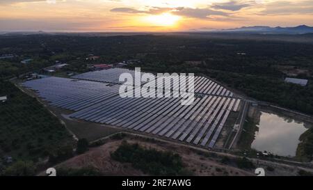 Luftaufnahme von Sonnenkollektoren im Hintergrund des Sonnenuntergangs, grünes, sauberes Konzept für alternative Energie. Sonneneinstrahlung über einem Photovoltaik-Kraftwerk. Stockfoto