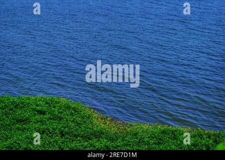 Tauchen Sie ein in den ruhigen Reiz eines malerischen Flusses in China, dessen kristallklares blaues Wasser den weiten blauen Himmel unter dem warmen emb reflektiert Stockfoto