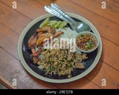 Thailändisches Essen, scharfer Schweinesalat (Larb Moo) und frittierter Schweinebauch mit Fischsauce und scharfer Dip-Sauce Stockfoto