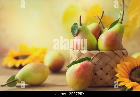 Frische, reife Birnen im Korb auf dem Holztisch. Bio-Früchte, Konzept der gesunden Ernährung mit Kopierraum. Stockfoto