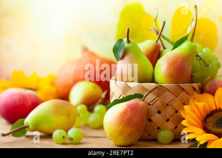 Herbstleben mit Obst, Blumen und Gemüse der Saison auf Holzhintergrund. Stockfoto