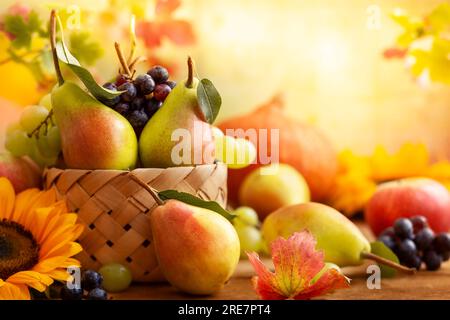 Herbstleben mit Obst, Blumen und Gemüse der Saison auf Holzhintergrund. Stockfoto