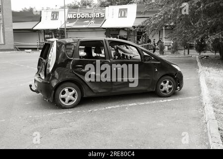ODESSA, UKRAINE - 14. Juli 2023: Krieg in der Ukraine. Ein zerstörtes ziviles Gebäude und zivile Fahrzeuge nach einem Raketenangriff. Ruinen des Krieges mit der Ukraine. R Stockfoto
