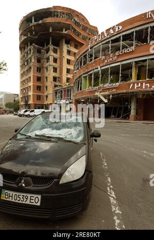 ODESSA, UKRAINE - 14. Juli 2023: Krieg in der Ukraine. Ein zerstörtes ziviles Gebäude und zivile Fahrzeuge nach einem Raketenangriff. Ruinen des Krieges mit der Ukraine. R Stockfoto