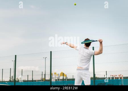 Rückhand, Mann in aktiver Kleidung, Tennis, Schläger halten, Ball schlagen, Rückhand, Rückansicht Stockfoto