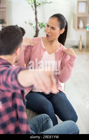 Wütend Paar kämpfen auf einer Couch zu Hause sitzen Stockfoto