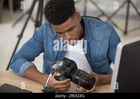 Ein Mann, der an einer Kamera arbeitet Stockfoto