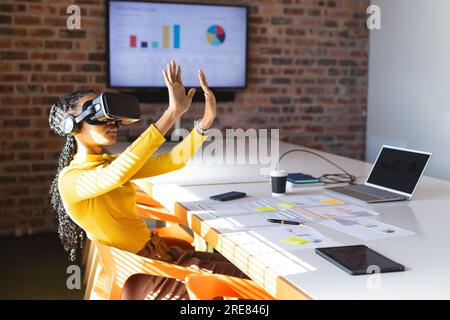 afroamerikanische Geschäftsfrau, die im Büro ein VR-Headset verwendet Stockfoto