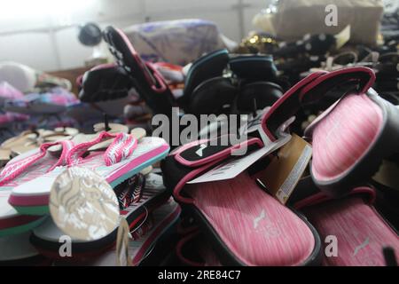 Eine Nahaufnahme von Flip-Flops, Sandalen und Slidern aus dem Blickwinkel nach oben, die in einem Touristenladen ausgestellt werden. Stockfoto