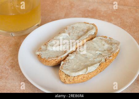 Nahaufnahme von Cabrales-Creme mit Apfelwein auf getoastetem Vollkornbrot. Traditionelle spanische Tapas und Speisen. Stockfoto
