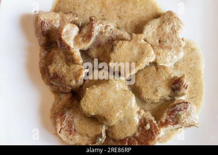 Ein Blick von oben auf saftige Sirloin-Medaillons, getränkt in einer Sekt-Cabrales-Käsesauce, hergestellt aus frischen Fleischsäften, auf einer weißen rechteckigen platte Stockfoto