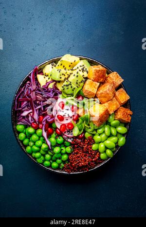 Vegane buddha-Schüssel mit roter Quinoa, gebratenem Tofu, Avocado, Edamambohnen, grünen Erbsen, Rettich, Kohl, Granatäpfel und Sesamsamen mit Sojasauce. Heilen Stockfoto