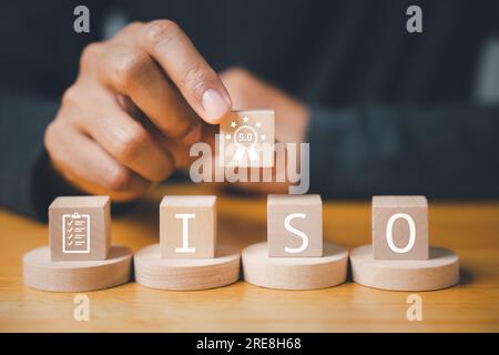 Der Finger eines Geschäftsmannes, der ISO-Holzwürfel drückt Stockfoto