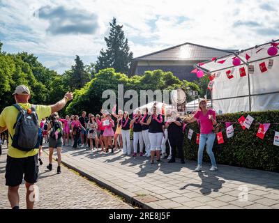 Eine Gruppe von Frauen sah, wie sie tanzten und die Teilnehmer anjubelten. Da es sich um das weltweit größte mehrtägige Walking-Event handelt, werden die International Four Days Marches (in niederländischer „De Vierdaagse“) als ein hervorragendes Beispiel für Sportlichkeit und internationale Bindungen zwischen Militärangehörigen, Frauen und Zivilisten aus vielen verschiedenen Ländern angesehen. Dieses Jahr war es die 105. Ausgabe, und die offizielle Anzahl der registrierten Walker betrug 43.363 aus 77 Ländern. Die Teilnehmer können 30km, 40km oder 50km Fuß pro Tag gehen. Am letzten Tag überquerten 39.019 Wanderer die Ziellinie. Nach einem festlichen Eintritt in die Via Gladio Stockfoto