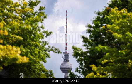 Berlin, Deutschland. 26. Juli 2023. Der Berliner Fernsehturm ist hinter grünen Bäumen vor einem bewölkten Himmel zu sehen. Kredit: Britta Pedersen/dpa/Alamy Live News Stockfoto