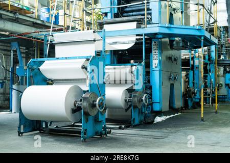 Große Druckerpresse mit Papierrollen-Druckzeitung auf der Produktionslinie der Industriedruckmaschine Stockfoto