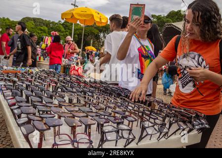 Goiania, Goias, Brasilien – 25. Juni 2023: Einige Menschen wählen während der Gay Pride Parade in Goiania eine Brille aus einer Präsentation auf der Straße. Stockfoto