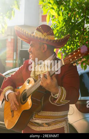 Der mexikanische Musiker Mariachi spielt Gitarre auf einer Stadtstraße. Stockfoto