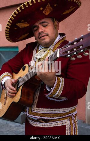 Der mexikanische Musiker Mariachi spielt Gitarre auf einer Stadtstraße. Stockfoto