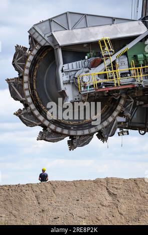 26. Juli 2023, Sachsen, Groitzsch: Ein Schaufelbagger „SRS 1300“ überquert die Bundesautobahn 176 auf dem Weg vom Tagebau Schleenhain zum ca. 10 km entfernten Bergbaufeld Peres. Die Maschine, die gut 1680 Tonnen wiegt, bewegt sich und wird ab dem Herbst weiterhin für den Braunkohlebergbau eingesetzt. Nach Angaben der Mitteldeutschen Braunkohlengesellschaft (Mibrag) ist der Bagger seit Juli 12 in Bewegung und wird am nächsten Montag am Zielort ankommen. Zum Schutz der Straße wurde die Straße mit Planen, Klebebändern und einer Schicht Kiessandmischung abgedeckt Stockfoto